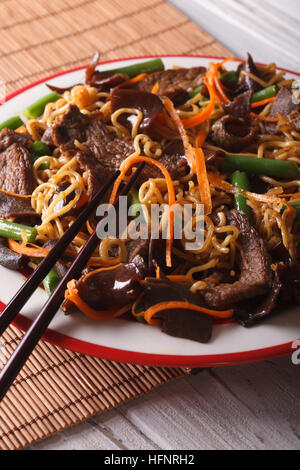 Lo Nudeln Mein Chinesisch mit Rindfleisch und Mauser Makro auf einem Teller. Vertikal Stockfoto