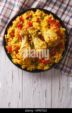 Spanische Paella mit Huhn und Gemüse auf einem Teller. vertikale Ansicht von oben Stockfoto