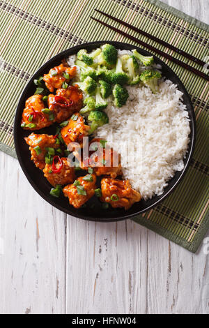 General Tso Chicken mit Reis, Zwiebeln und Brokkoli auf den Tisch. vertikale Ansicht von oben Stockfoto