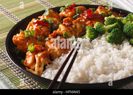 Tso asiatischen Huhn mit Reis und Broccoli Nahaufnahme auf einer Platte. Horizontale Stockfoto