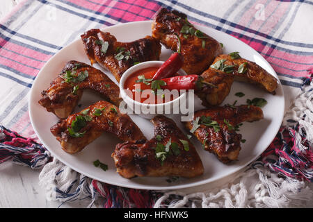 Lecker gegrillte Hähnchenflügel mit Chilischoten Nahaufnahme auf einer Platte. horizontale Stockfoto