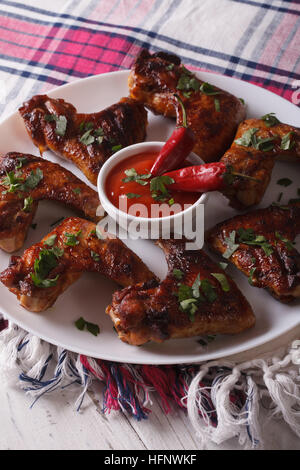 gegrillte Hähnchenflügel mit Chilischoten Nahaufnahme auf einer Platte heiß. vertikale Stockfoto