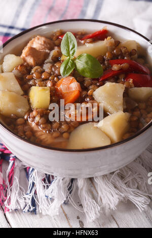 braune Linsensuppe mit Gemüse und Fleisch hautnah auf dem Tisch. vertikale Stockfoto