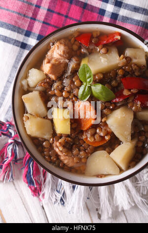Linsensuppe mit Gemüse und Fleisch hautnah auf dem Tisch. vertikale Ansicht von oben Stockfoto