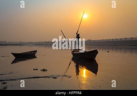 Silhouette Boot mit Ruderer bei Sonnenuntergang am Fluss Damodar, Durgapur Barrage, West Bengal, Indien. Stockfoto