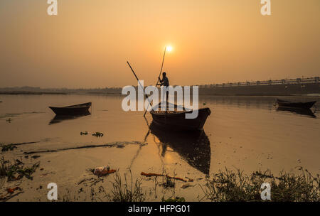 Holzboot mit Ruderer bei Sonnenuntergang am Fluss Damodar, Durgapur Barrage, West Bengal, Indien. Stockfoto