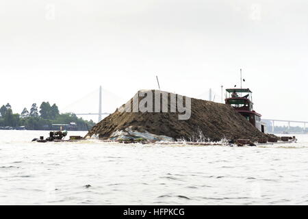 MY THO, VIETNAM - 14 Februar: Boot mit Boden schwimmend auf Mekong mit Rach Mieu Brücke am 14. Februar 2012 in My Tho, Vietnam. Stockfoto