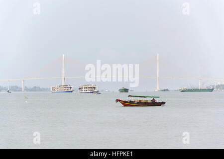 MY THO, VIETNAM - 14 Februar: Boot mit Boden schwimmend auf Mekong mit Rach Mieu Brücke am 14. Februar 2012 in My Tho, Vietnam. Stockfoto