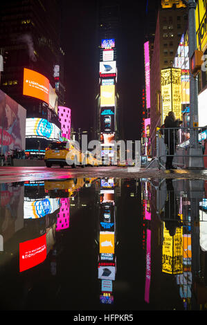 NEW YORK CITY - 19. Dezember 2016: Gelben Taxis Pass unter den hellen Lichtern des Times Square als Schnee schmilzt von den letzten Sturm. Stockfoto