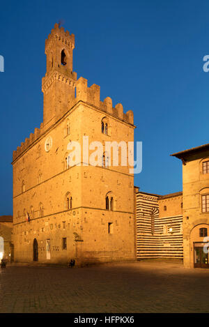 Dämmerung über Palazzo dei Priori und die mittelalterliche Stadt Volterra, Toskana, Italien Stockfoto