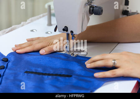 Frauen Hände hinter ihr Nähen-blau Stockfoto