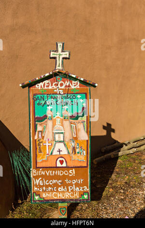 Volkskunst-Zeichen für die historischen San Francisco de Asis Missionskirche in Ranchos de Taos Plaza, Taos, New Mexiko. Die Adobe-Kirche erbaut im Jahre 1772 und berühmt geworden in Gemälde des Künstlers Georgia O'Keeffe. Stockfoto