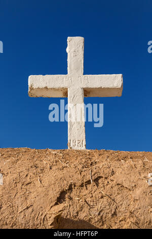 Ein weißes Kreuz auf die historischen San Francisco de Asis Missionskirche in Ranchos de Taos Plaza, Taos, New Mexiko. Die Adobe-Kirche erbaut im Jahre 1772 und berühmt geworden in Gemälde des Künstlers Georgia O'Keeffe. Stockfoto