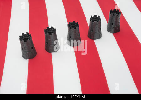 Schwarze Burg auf US Stars & Stripes - als Metapher für möglich, uns Isolationismus und Protektionismus Politik unter neuer Verwaltung, uns China Handelskrieg. Stockfoto