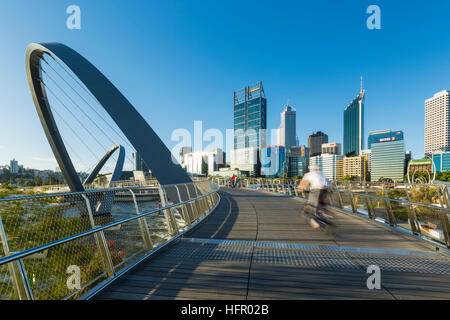 Radfahrer der Elizabeth Quay-Brücke mit der Skyline der Stadt darüber hinaus, Perth, Western Australia, Australien Stockfoto