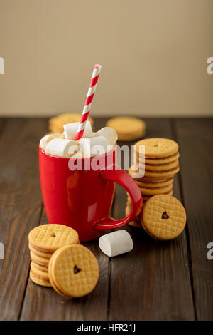 Marshmallows in einer Tasse mit Cookies mit Herzen aus der Patsche. Stockfoto
