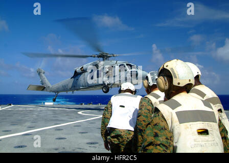 060214-N-4772B-014 Philippinensee (14. Februar 2006) - Combat-Cargo-Marines Orthese selbst als ein MH-60 Seahawk Hubschrauber landet auf dem Flugdeck der amphibischen Dock Landungsschiff USS Harper Ferry (LSD-49). Die drei-Schiff, Sasebo-basierte vorwärts bereitgestellt amphibische bereit Gruppe ist bestehend aus USS Essex (LHD-2), USS Juneau (LPD-10) und Harpers Ferry derzeit auf den Frühling-Patrouille. Foto: U.S. Navy Journalist 2. Klasse Brian P. Biller (freigegeben) US Navy 060214-N-4772B-014 bekämpfen Cargo Marines stemmen sich als ein MH-60 Seahawk Hubschrauber landet auf dem Flugdeck der amphibischen dock lan Stockfoto