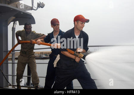 060324-N-2420K-042 Pointe Noire, Kongo (24. März 2006) - Segler an Bord der u-Boot-tender USS Emory S. Land (AS-39) und Mitglied der kongolesischen militärische Praxis Brandbekämpfung Schlauch Umgang mit Techniken zugewiesen. Land führt derzeit Trainingsübungen und Gemeinschaftsprojekte RelationÕs (COMREL) mit Host Staatsangehörigen während auf Bereitstellung bis zum Golf von Guinea. Foto: U.S. Navy des Fotografen Mate 2. Klasse Jonathan Kulp (freigegeben) US-060324-N-2420K-042 Marineseeleute zugewiesen an Bord des u-Boots Ausschreibung USS Emory S. Land (AS-39) und Mitglied der kongolesischen militärische Praxis Firefighti Stockfoto