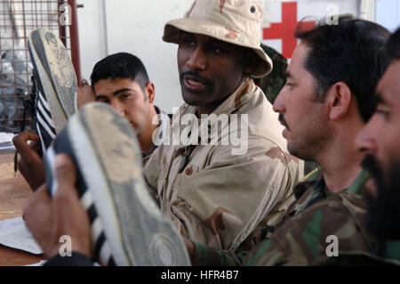 060402-N-2653P-332 Kabul, Afghanistan (2. April 2006) - Lagerhalter 1. Klasse Melvin Hayden inspiziert Sportschuhe Afghan National Army Rekruten an die ausstellende Zentralstelle (CIF) an die neue Kabul Military Training Anlage (KMTF) befindet sich in Afghanistan austauschen wollen. US Navy Kaufleute sind nach Phoenix kombiniert Joint Task Force (CJTF) zur logistischen Unterstützung für eines der weltweit neuesten Armeen eingesetzt. Foto: U.S. Navy Journalist 1. Klasse James G. Pinsky (freigegeben) Marine 060402-N-2653P-332 Lagerhalter 1. Klasse Melvin Hayden inspiziert Sportschuhe Afghan National Army R Stockfoto