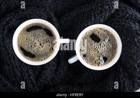 Draufsicht auf zwei kleine Tassen Kaffee, umgeben von einem schwarzen Schal Stockfoto