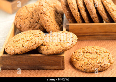 Eine Menge von Haferflocken Cookies in zwei Holzkisten auf einem braunen Stoff mit Unschärfe und flachen Schärfentiefe Stockfoto