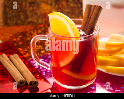 Transparente Tasse Tee mit Zitrusfrüchten, Zimt und Orange, hell glänzenden Hintergrund Stockfoto
