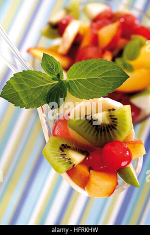 Obstsalat: Kiwis, Trauben, Äpfel, Bananen, Mangos und Kirschen Stockfoto