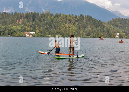 Unbekannte Menschen genießen standup Paddle boarding in einem heißen sonnigen Tag im See von Bled, Slowenien. Stockfoto