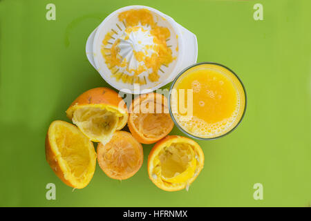 Glas frisch gepresster Orangensaft mit Squeezer und Orange Reste Stockfoto