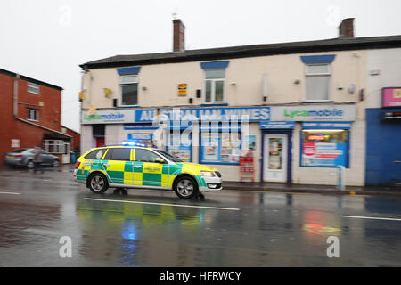 Ein North West Ambulance Service-Fahrzeug auf dem Weg zu einem weiteren Vorfall geht die Szene in Ashton Road, Oldham, wo ein Silvester-Absturz eine 12 Jahre altes Mädchen getötet und links ein weiteres Kind kämpfen um ihr Leben im Krankenhaus. Stockfoto