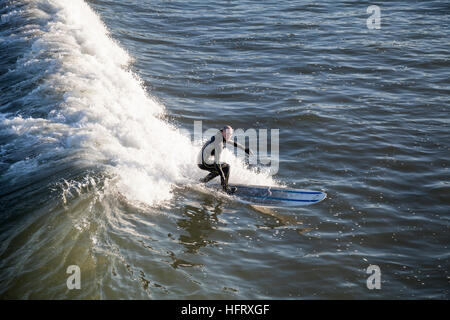 Ein Mann am Meer im Nordosten Englands vor der Küste bei Saltburn Surfen Stockfoto