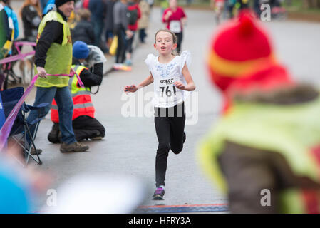 Anmerkung des Herausgebers: elterliche Erlaubnis Rosalie Leban, 9, überquert die Ziellinie in der Serpentine Neujahrs Tag 3k Fun Run im Hyde Park, London. Stockfoto