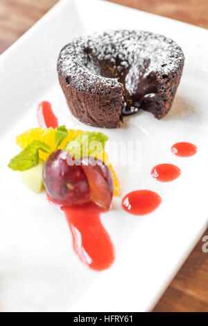 Schokoladen-Fondant-Lava-Kuchen mit Eis und frischen Früchten Stockfoto