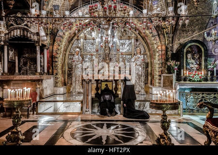 Jerusalem, Israel - 26. Dezember 2010: Zwei orthodoxe Kirche Nonnen beten auf den Knien vor dem Altar Kreuzigungen in Heilig-Grab-Kirche Stockfoto