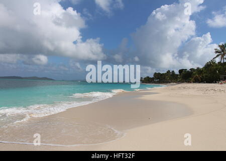 Blick entlang einer einsamen karibischen Strand mit weißem Sand und blauem Himmel Stockfoto