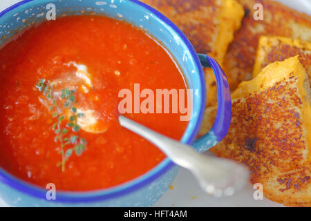 Tomaten-Suppe in einem Topf Schüssel mit einem Käse-Sandwich in Dreiecke schneiden Stockfoto