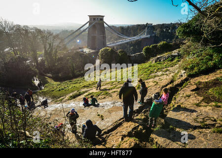 Kinder rutschen eine Naturstein-Rutsche, die von Generationen von Kindern gleiten hangabwärts Kalkstein in der Nähe von Clifton Suspension Bridge auf Clifton Downs, Bristol, wie Teile des Vereinigten Königreichs von eisigen Bedingungen gepackt werden, wie eine Erkältung snap startet 2017 erstellt wurde. Stockfoto