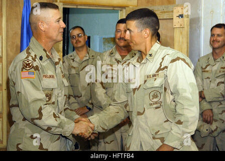 051111-N-3750S-007 Al Asad, Irak Ð (11. November 2005) - US Armee Command Sergeant Major Jeffrey Mellinger, Multi-National Force Irak links erkennt Konstruktionsmechaniker 2. Klasse Derrick Majchszak harte Arbeit mit einem Handschlag und seinem Befehl Münze. Mellinger sprach und präsentiert Münzen während einer außerplanmäßigen Besuch in Naval Mobile Bau-Bataillon zwei zwei (NMCB-22). NMCB-22 wird derzeit in den Irak zur Unterstützung der globalen Krieg gegen den Terrorismus eingesetzt. Foto: U.S. Navy Journalist 1. Klasse Leslie A. Shively (RELREASED) US Navy 051111-N-3750S-007 US Armee Command Sergeant Major Jeffrey Mellinger, Multi-N Stockfoto