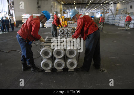 070406-N-3659B-178 SOUTH CHINA SEA (6. April 2007) - Aviation Ordnancemen befestigen Hebe-Schlingen, eine Kiste Munition für den Transfer entlasten damit das Military Sealift Command (MSC) Munition Schiff USNS Flint (T-AE 32) während ein Kampfmittel Evolution an Bord der USS Ronald Reagan (CVN-76). Ronald Reagan Carrier Strike Group (CSG) läuft auf einer Welle Bereitstellung zur Unterstützung der US-Militäroperationen im westlichen Pazifik. Foto: U.S. Navy Mass Communication Specialist 2. Klasse Joseph M. Buliavac (freigegeben) US Navy 070406-N-3659B-178 Aviation Ordnancemen legen Hebe-Schlingen auf eine Kiste oder Stockfoto