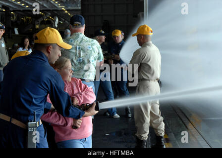 070417-N-3659B-298 PACIFIC OCEAN (17. April 2007) - Chief Storekeeper Eugene Chua, Mitglied der Schadensbegrenzung Ausbildungsteam an Bord der USS Ronald Reagan (CVN-76), lehrt Feuerwehrschlauch Umgang mit Techniken, um eine junge "Tiger" während Tiger allgemeine Viertel in der Hangarbucht. Fast 500 Familienmitgliedern und Freunden trat Segler zugewiesen, Ronald Reagan Carrier Strike Group (CSG) für einen Tiger Cruise, ihre Angehörigen bei der Arbeit zu sehen. Foto: U.S. Navy Mass Communication Specialist 2nd Class Joseph M. Buliavac (RELEASED) US Navy 070417-N-3659B-298 Chief Storekeeper Eugene Chua, ein Mitglied der Schaden Co Stockfoto