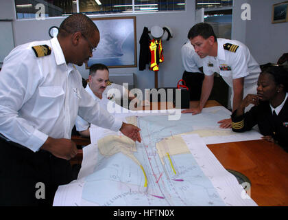 090713-N-1655H-129 (13. Juli 2009), DURBAN, Südafrika Durban Harbour Master Rufus Lekala, links, beschreibt das Layout der lokale Sender mit Captain Jim Tranoris, hinten links, Commodore Commander Task Force 363 und CMdR Bob Moum, oben rechts, Kommandierender Offizier der geführte Flugkörper Zerstörer USS Arleigh Burke (DDG-51). Arleigh Burke ist in Durban zum Auftakt einer Reihe von Übungen mit der South African Navy. (Foto: U.S. Navy Mass Communication Specialist 2. Klasse David Holmes/freigegeben) US Navy 090713-N-1655H-129 Durban Harbour Master Rufus Lekala, beschreibt links, das Layout der lo Stockfoto