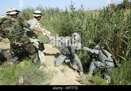 070712-N-9500T-105 KHAN BANI SA, Irak (12. Juli 2007) Ð US Armee Sgt. Steven Calhoun wird unterstützt von Soldaten der irakischen Armee in ein Soldat herausziehen, nachdem er während einer gemeinsamen Mission in eine Bewässerung Graben fiel.  Zugewiesen, Alpha Batterie, 2. Bataillon, 12. Infanterie-Regiment, 2nd Infantry Division und Einheiten der irakischen Armee Soldaten führen eine Kordon und Suche Mission um Bereich der Aufständischen zu löschen und cache-Seiten. Foto: U.S. Navy Mass Communication Specialist 2. Klasse Scott Taylor (freigegeben) US Navy 070712-N-9500T-105 US Armee Sgt. Steven Calhoun wird unterstützt durch die irakische Armee Sol Stockfoto
