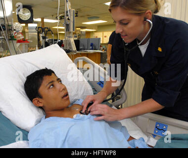 070731-N-4238B-007 ACAJUTLA, El Salvador (31. Juli 2007) - Lt. Megan Zeller, eine Intensivstation Krankenschwester, prüft die Vitalfunktionen des Patienten, während er nach der Operation an Bord das Lazarettschiff USNS Comfort (T-AH 20) erholt. Komfort ist auf eine viermonatige humanitären Einsatz in Lateinamerika und der Karibik, die medizinische Versorgung für Patienten in einem Dutzend Ländern. Foto: U.S. Navy Mass Communication Specialist 3. Klasse Kelly E. Barnes (freigegeben) US Navy 070731-N-4238B-007 Lt. Megan Zeller, eine Intensivstation Krankenschwester, prüft die Vitalfunktionen des Patienten, während er nach der Operation Aboar erholt sich Stockfoto