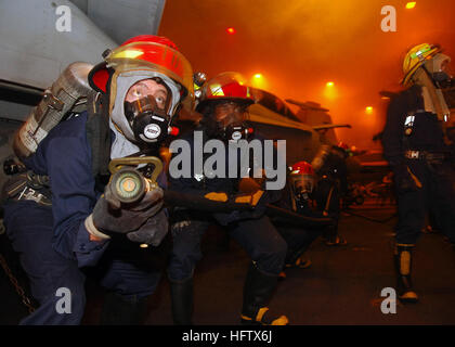 070808-N-0916O-147 Arabisches Meer (8. August 2007) - Mitglieder aus einem Bravo Feuer Team vorwärts suchen einen simulierten Brand im Hangar Bucht während einer allgemeinen Viertel (GQ) Drill an Bord der nuklear angetriebene Flugzeugträger USS Enterprise (CVN-65). Enterprise und eingeschifften Carrier Air Wing (CVW) 1 sind im Gange auf einen geplanten sechsmonatigen Einsatz zur Unterstützung der globalen Krieg gegen den Terrorismus. Foto: U.S. Navy Mass Communication Specialist 3. Klasse Octavio N. Ortiz (freigegeben) US Navy 070808-N-0916O-147 Mitglieder aus einem Bravo Feuer Team vorwärts bewegen, um die Suche nach eines simulierten Brand im Hangar Stockfoto