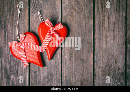 Valentinstag Hintergrund. Paar rote Herzen mit karierten Band auf hölzernen Hintergrund. Ansicht von oben Stockfoto