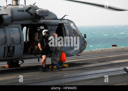 071223-N-6125G-030 Persischen Golf (23. Dezember 2007) die letzte der sieben überlebenden Schiffbrüchigen auf dem Flugdeck der Nimitz-Klasse nuklear angetriebene Flugzeugträger USS Harry S. Truman (CVN-75) begleitet wird, nach seiner Rettung auf See durch zwei MH-60 Seahawk Hubschrauber, zugeordnet der "Ritter des Meeres" der Hubschrauber Meer Kampf Geschwader (HSC) 22 startete an Bord des Schiffes schnell Kampfunterstützung USNS Arctic (T-AOE-8). Die Seeleute wurden geborgen, nachdem ihre Dhau in rauer See versank. Truman und der Arktis werden bis zum Persischen Golf im Rahmen der laufenden Rotation zur Gefahrenabwehr in Unterstützung bereitgestellt. Stockfoto