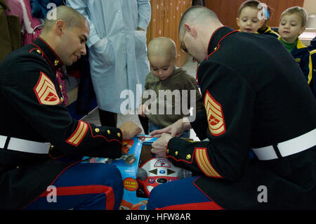 091216-O-0000 X-562 PESCOPAGANO DI MONDRAGONE, Italien (16. Dezember 2009) US Marine Staff Sgt Denis Licona, links, zugewiesen, der Befehl US Naval Forces Europa/Afrika, U.S. 6. Flotte Personal und Gunnery SGT Jarod Herzog, der Kommandant, Strike Force NATO Mitarbeiter zugewiesen helfen, öffnen Sie ein Geschenk für einen jungen in eine Gemeinschaft-Relations-Veranstaltung am Istituto Piccola Casetta di Nazareth, eine Schule für benachteiligte Kinder. Marines und Segler gespendet-Geschenke für 60 Kinder im Rahmen der Marine Corps Spielwaren für Tots 2009 Weihnachten Laufwerk. (Foto von Daniela Muto/freigegeben) US Navy 091216-O-0000 X-562 Marines donat Stockfoto