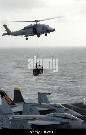 Ein MH-60 s Knighthawk, zugeordnet zu den "Totschläger" Hubschrauber Meer Kampf Geschwader 21, bereitet sich auf Ladung übertragen aus dem Fast-Kampf Unterstützung Schiff USNS Rainier (T-AOE 7) auf dem Flugzeugträger USS Ronald Reagan (CVN-76) während ein Nachschub auf See zu liefern. RAS wird durchgeführt, um Schiffe mit Lebensmitteln, Mail und Hilfsgütern zu versorgen, ohne ziehen in den Hafen. Ronald Reagan ist derzeit in den USA im Einsatz 5. Flotte Aufgabengebiet. In den USA 5. Flotte konzentrieren sich auf regionale Partner der US-Gesundheitsbehörde Engagement für Sicherheit, die Stabilität und globale Profis fördert beruhigend Stockfoto