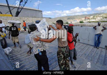 080923-N-9620B-004 GONAIVES, Haiti (23. September 2008) Boatswain Mate 3. Klasse Christian Farfan, eingeschifft auf amphibischer Angriff Schiff USS Kearsarge (LHD-3), hilft einen Haitian Relief Arbeiter entladen, Nahrung und Wasser, helfen den betroffenen durch den letzten Wirbelstürme, die Haiti getroffen zu haben. Kearsarge hat US-Militärangehörige aus allen militärischen Bereichen und einer multinationalen Gruppe von medizinischen und Support-Mitarbeiter begonnen. U.S. (Foto: U.S. Navy Mass Communication Specialist 2. Klasse Erik C. Barker/freigegeben) US Navy 080923-N-9620B-004 Boatswain Mate 3. Klasse Christian Fischer an Bord der Ladeeffekt in Angriff genommen Stockfoto