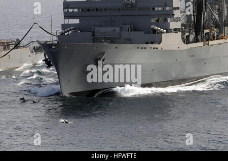 081015-N-3659B-372 Golf von OMAN (15. Oktober 2008) Delphine springen aus dem Wasser vor dem Bug des Military Sealift Command schnell Kampfunterstützung Schiff USNS Brücke (T-AOE 10) während einer Auffüllung am Meer zwischen Brücke und der Ticonderoga-Klasse geführte Flugkörper Kreuzer USS Chancellorsville (CG-62). (Foto: U.S. Navy Mass Communication Specialist 2. Klasse Joseph M. Buliavac/freigegeben) US Navy 081015-N-3659B-372-Delphine springen aus dem Wasser vor dem Bug des Military Sealift Command schnell Kampfunterstützung Schiff USNS Brücke (T-AOE 10) während einer Auffüllung auf hoher See Stockfoto